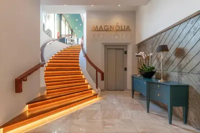 a staircase in a building with a blue cabinet and a blue table at Enotel Magnólia in Funchal