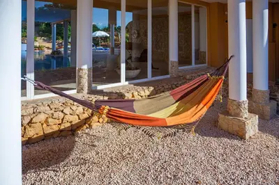 a hammock sitting outside of a house with a building at Montinho De Ouro in Luz