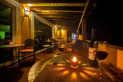 a table with two glasses of wine and a candle at Montinho De Ouro in Luz