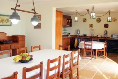 a kitchen with a table with a bowl of fruit on it at Colina Da Faja in Fajã da Ovelha