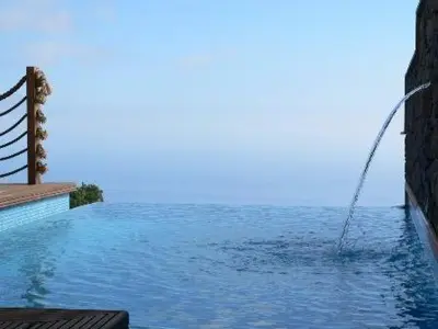 a swimming pool with a water hose in the water at Colina Da Faja in Fajã da Ovelha
