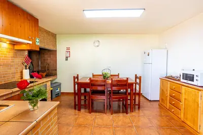 a kitchen with a table and chairs and a refrigerator at Casa Miguel in Machico