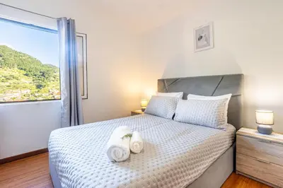 a bedroom with a bed with two towels on it at Casa Miguel in Machico