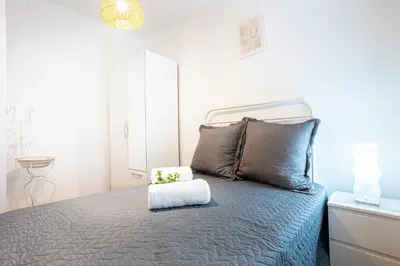 a white bedroom with a bed with a white headboard at Casa Miguel in Machico