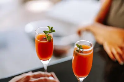 two glasses filled with orange cocktails on a table at Muthu Raga Madeira Hotel in Funchal