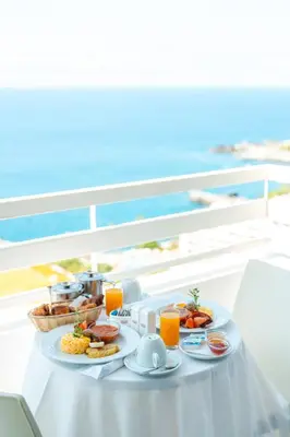 a table with breakfast foods and drinks on a balcony at Muthu Raga Madeira Hotel in Funchal
