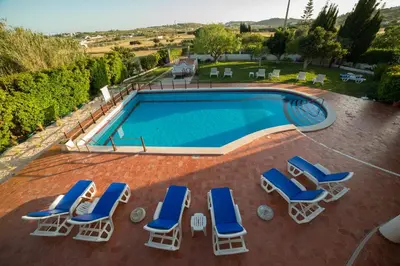 an overhead view of a swimming pool with chaise lounge chairs and a swimming pool at Casa Rosa Montes in Luz