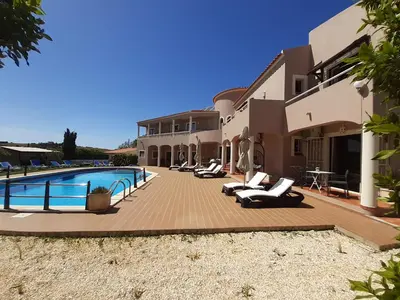 a resort with a swimming pool and lounge chairs at Casa Rosa Montes in Luz