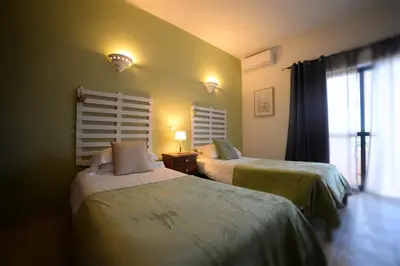 a hotel room with two beds and a window at Casa Rosa Montes in Luz
