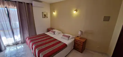 a bedroom with a bed with a striped blanket at Casa Rosa Montes in Luz