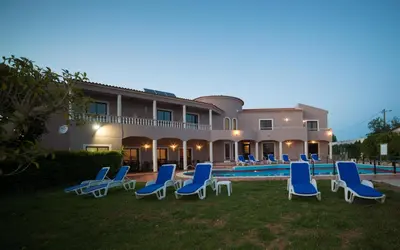 a villa with a swimming pool and blue lounge chairs at Casa Rosa Montes in Luz