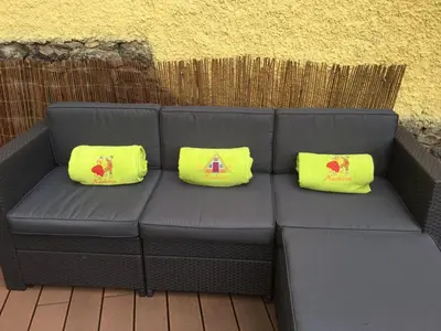two yellow pillows are sitting on a black couch at Casa Amarela in Funchal