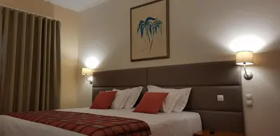 a hotel room with a large bed with red pillows at Hotel O Colmo in Santana