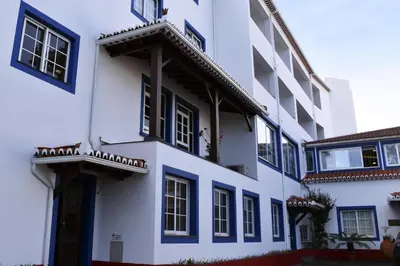 a white building with black windows and a door at Hotel O Colmo in Santana