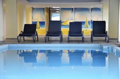 three chairs sitting next to a swimming pool at Hotel O Colmo in Santana