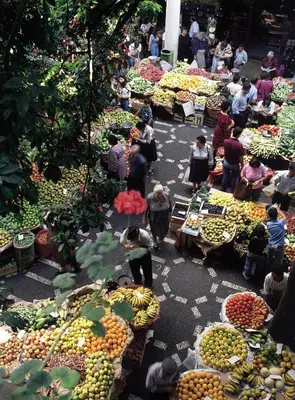 a group of people in a market with fruits and vegetables at Madeira Bright Star by Petit Hotels in Funchal