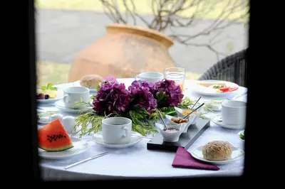 a table with plates of food and flowers on it at Quinta Da Cova Do Milho in Santo da Serra