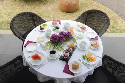 a white table with plates of food and flowers on it at Quinta Da Cova Do Milho in Santo da Serra