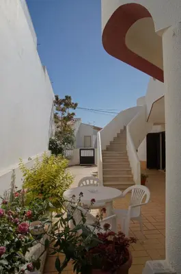 a patio with a table and chairs and stairs at Apartamentos e Quartos Atalaia in Sagres