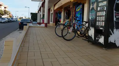 a bike parked on a sidewalk in front of a store at Apartamentos e Quartos Atalaia in Sagres