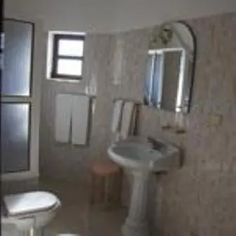 a bathroom with a sink and a toilet and a mirror at Apartamentos e Quartos Atalaia in Sagres