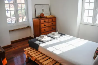 a bedroom with a bed and a wooden door at Jaca Hostel Porto da Cruz in Porto da Cruz