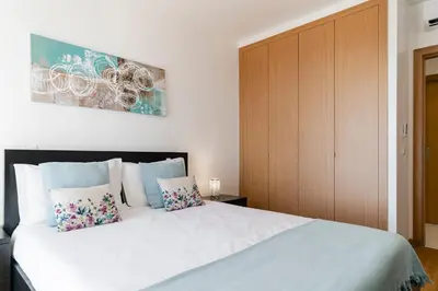a bedroom with a large white bed with two pillows at Caniço VI by An Island Apart in Santa Cruz