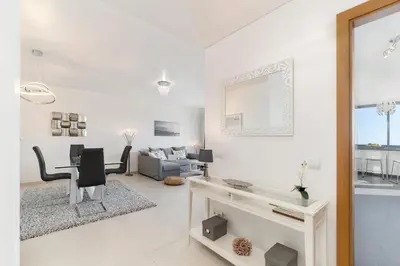 a white living room with a table and a couch at Caniço VI by An Island Apart in Santa Cruz