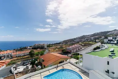 a view of the ocean from the balcony of a building at Caniço VI by An Island Apart in Santa Cruz
