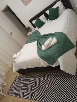 a bedroom with a large white bed with blue pillows at Hospedaria Pôr do Sol in Funchal