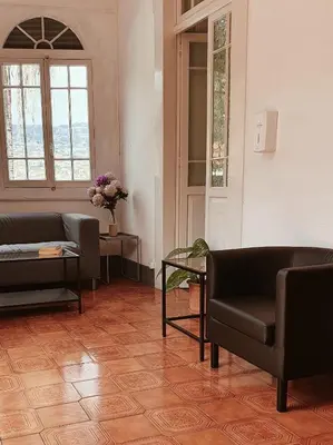 a desk with a chair and a book shelf with books at Hospedaria Pôr do Sol in Funchal