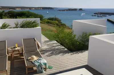 a view of a building with a patio and grass at Memmo Baleeira - Design Hotels in Sagres