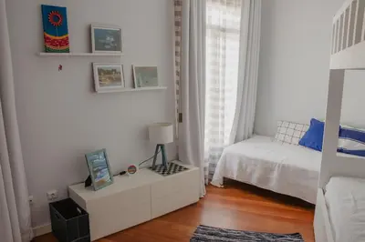 a white bedroom with a bed and a window at Colina Mar in Funchal