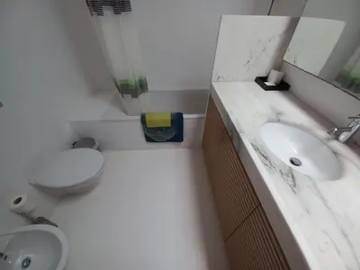 a white bathroom with a toilet and a sink at Casa dos Pátios in Sagres
