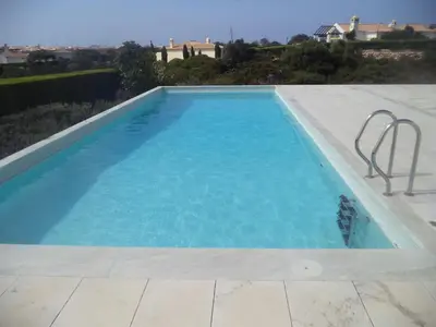 a large swimming pool with blue water at Casa dos Pátios in Sagres