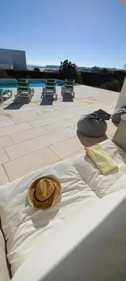 a straw hat sitting on a bed on a patio at Casa dos Pátios in Sagres