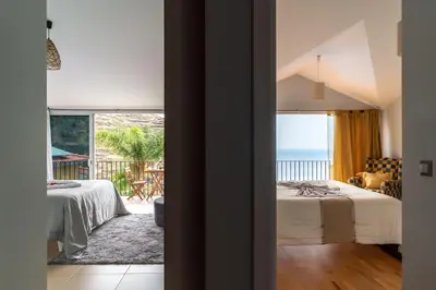 a bedroom with a bed and a view of the ocean at Zeza´s house in Calheta