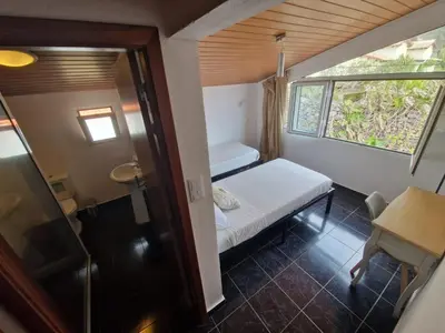 a small room with a small bed and a window at Cecília's House in Jardim do Mar
