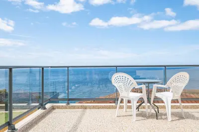 two chairs and a table on a balcony with the ocean at Casa do Calhau in Jardim do Mar