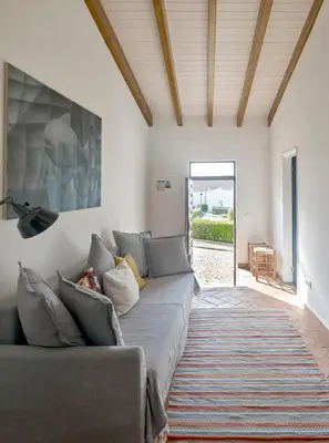 a living room with a couch and a painting on the wall at Casa Iemanjá in Vila do Bispo