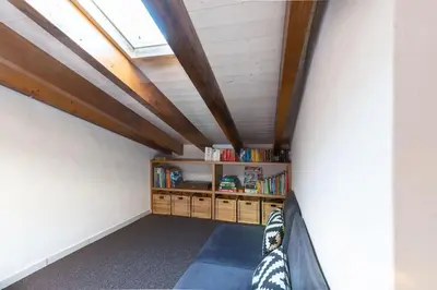 a attic room with a bed and a book shelf at Casa Iemanjá in Vila do Bispo