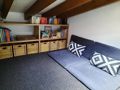 a blue couch in a room with a book shelf at Casa Iemanjá in Vila do Bispo