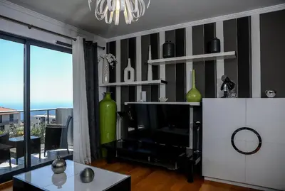 a living room with a flat screen tv and a table at Apartamento Boutique Ana Lúcia in Santa Cruz