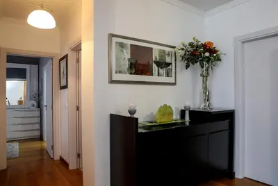 a living room with a vase of flowers on a dresser at Apartamento Boutique Ana Lúcia in Santa Cruz