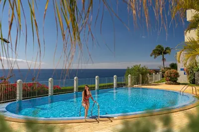 a woman standing in front of a swimming pool at Arcadas III by An Island Apart in Funchal