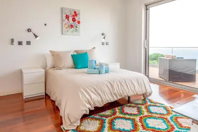 a bedroom with a bed and a large window at Villa Chimera By LovelyStay in Caniço