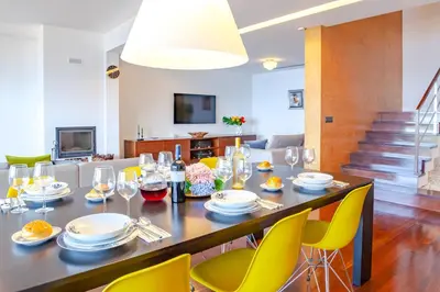 a dining room with a table and yellow chairs at Villa Chimera By LovelyStay in Caniço