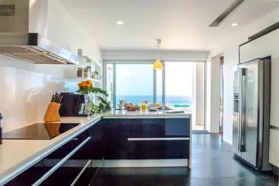 a kitchen with a view of the ocean at Villa Chimera By LovelyStay in Caniço