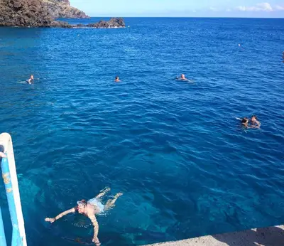 a group of people swimming in the water at Apartment Blue Sea in Paul do Mar