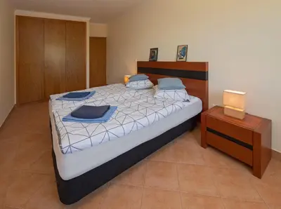 a bedroom with a large bed and a night stand at Apartment Blue Sea in Paul do Mar